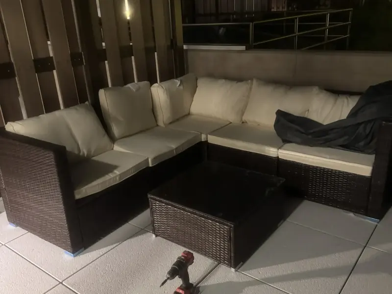 Rattan outdoor sectional and coffee table assembled on a tiled terrace
