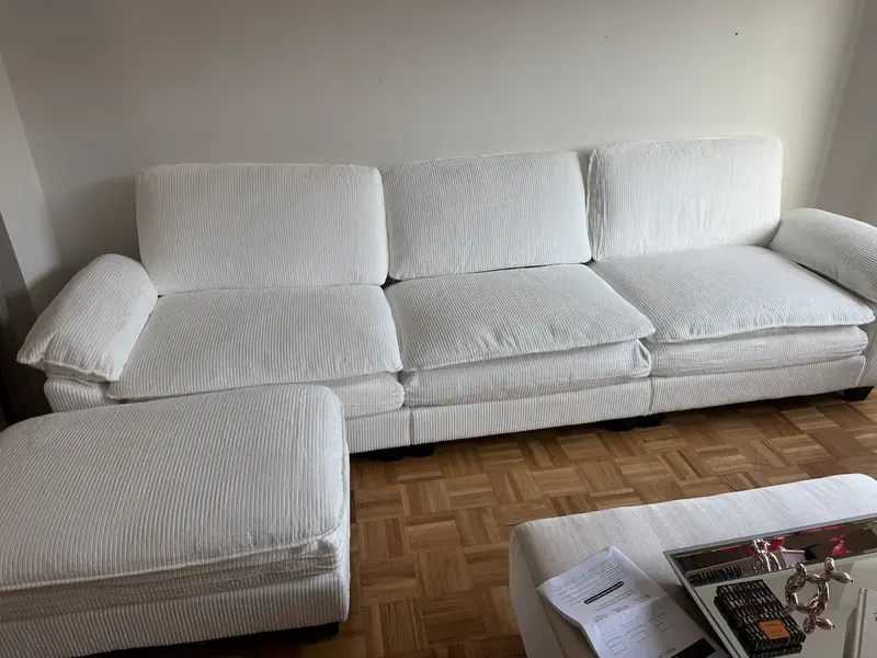 White sectional sofa assembled and squared on a parquet floor