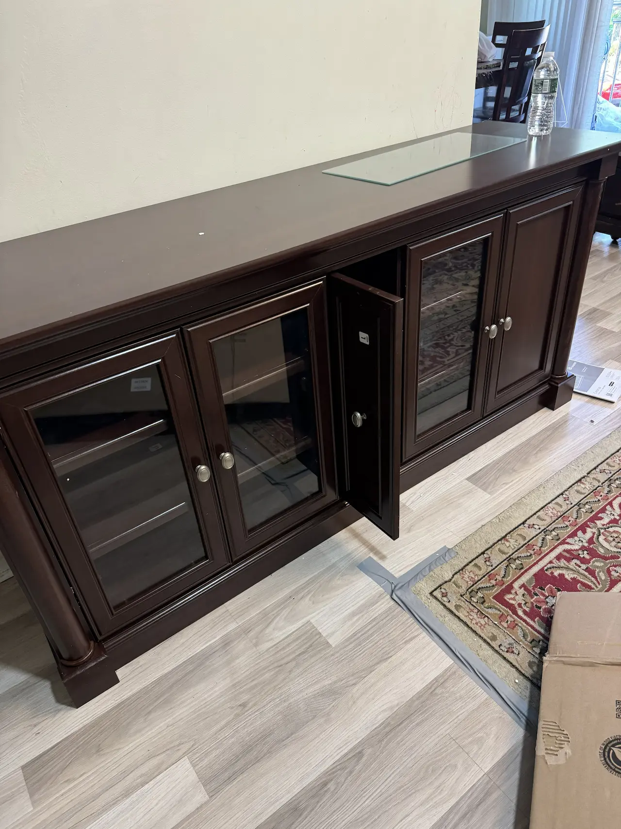 Dark wood sideboard cabinet with glass doors assembled square and aligned — NYC apartment