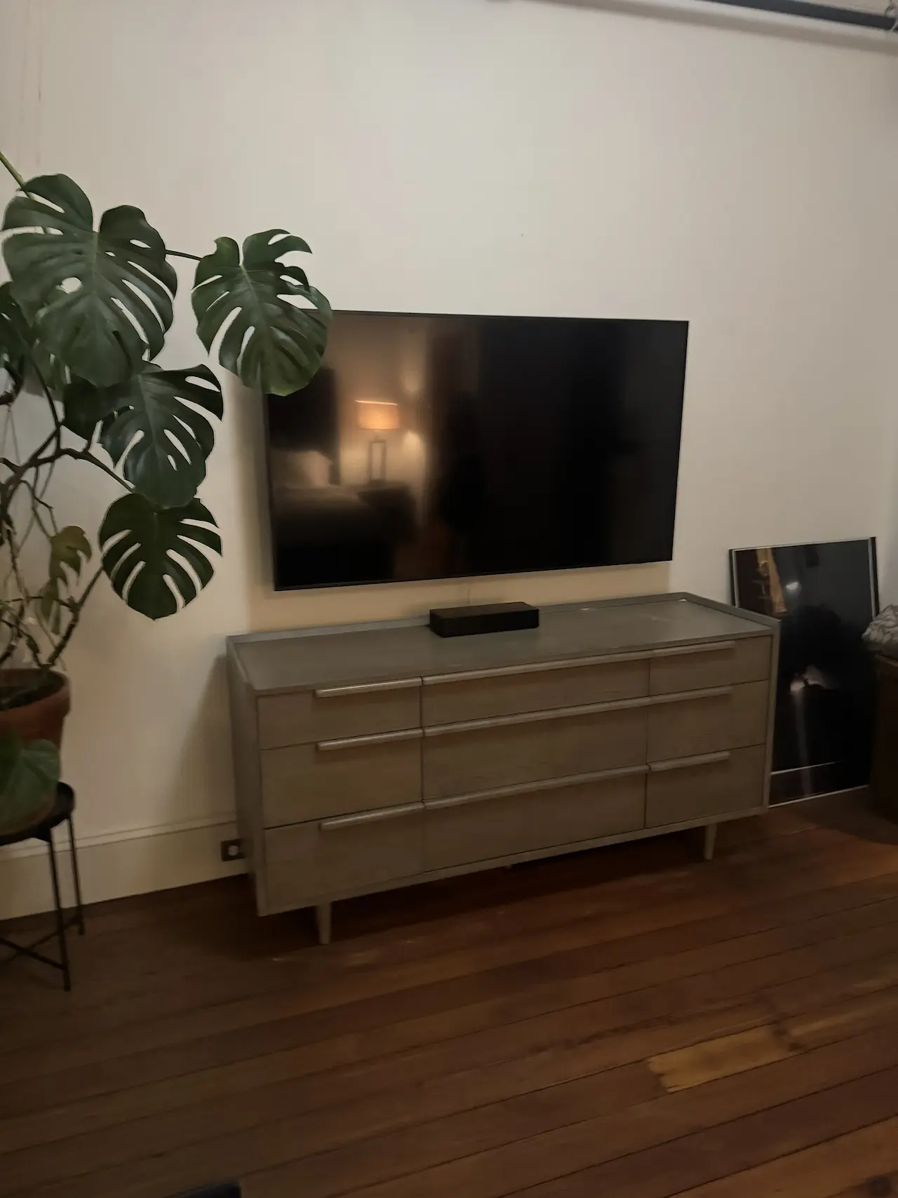 Wall-mounted art centered above a media console with perfect spacing and level alignment — Manhattan apartment