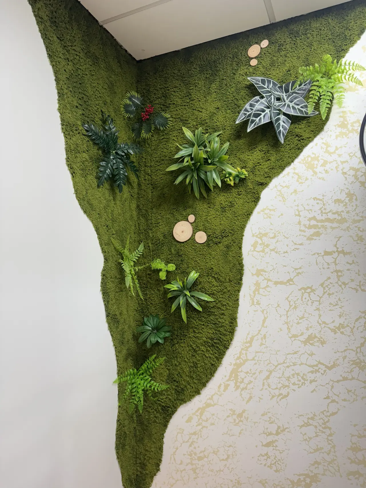 Preserved moss wallcovering wrapped into an inside corner with integrated faux botanicals — NYC commercial interior